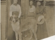 Kaks noort naist koeraga lävel, kolmas paistamas ukse tagant. 1907 - EAA