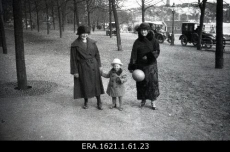 Kaks tundmatut naist koos lapsega linnapargis jalutamas [1920-1930ndad?]