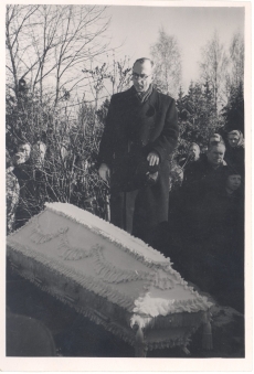 Anna Haava matus Tartu Maarja kalmistul. Puusärk lahtisel haual. Haua äärel seismas Mart Raud.